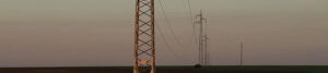 Banner crop of a picture of power lines and towers going through an agriculture land