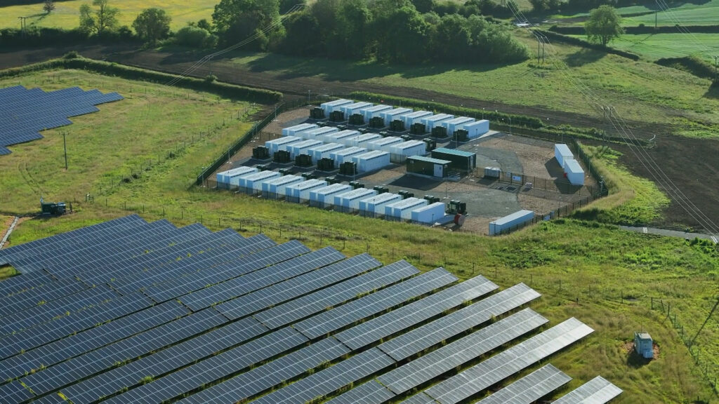 Aerial view of a solar farm with battery storage system connected to it.